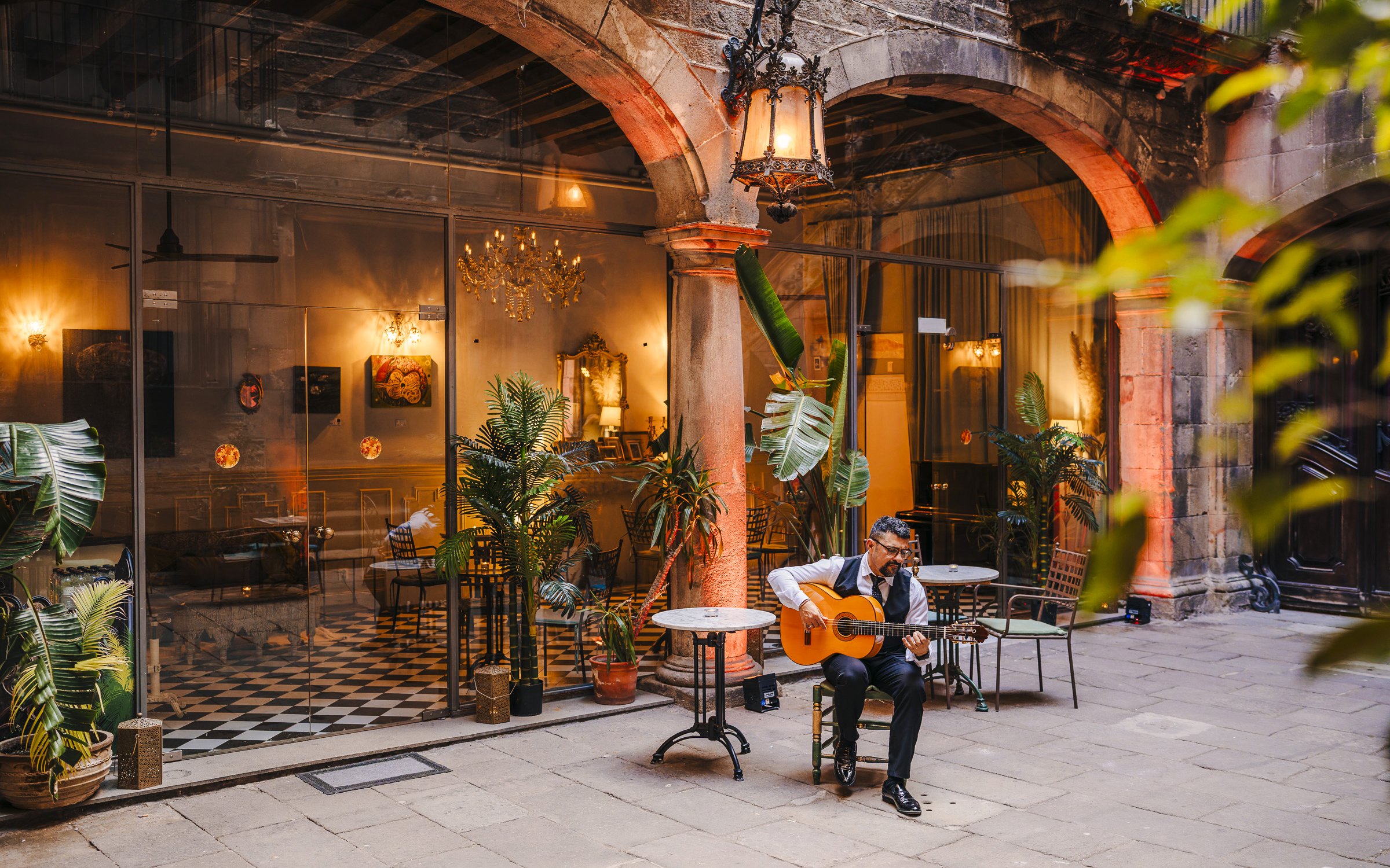 Guitarist performing at Palau Dalmases courtyard in Barcelona.