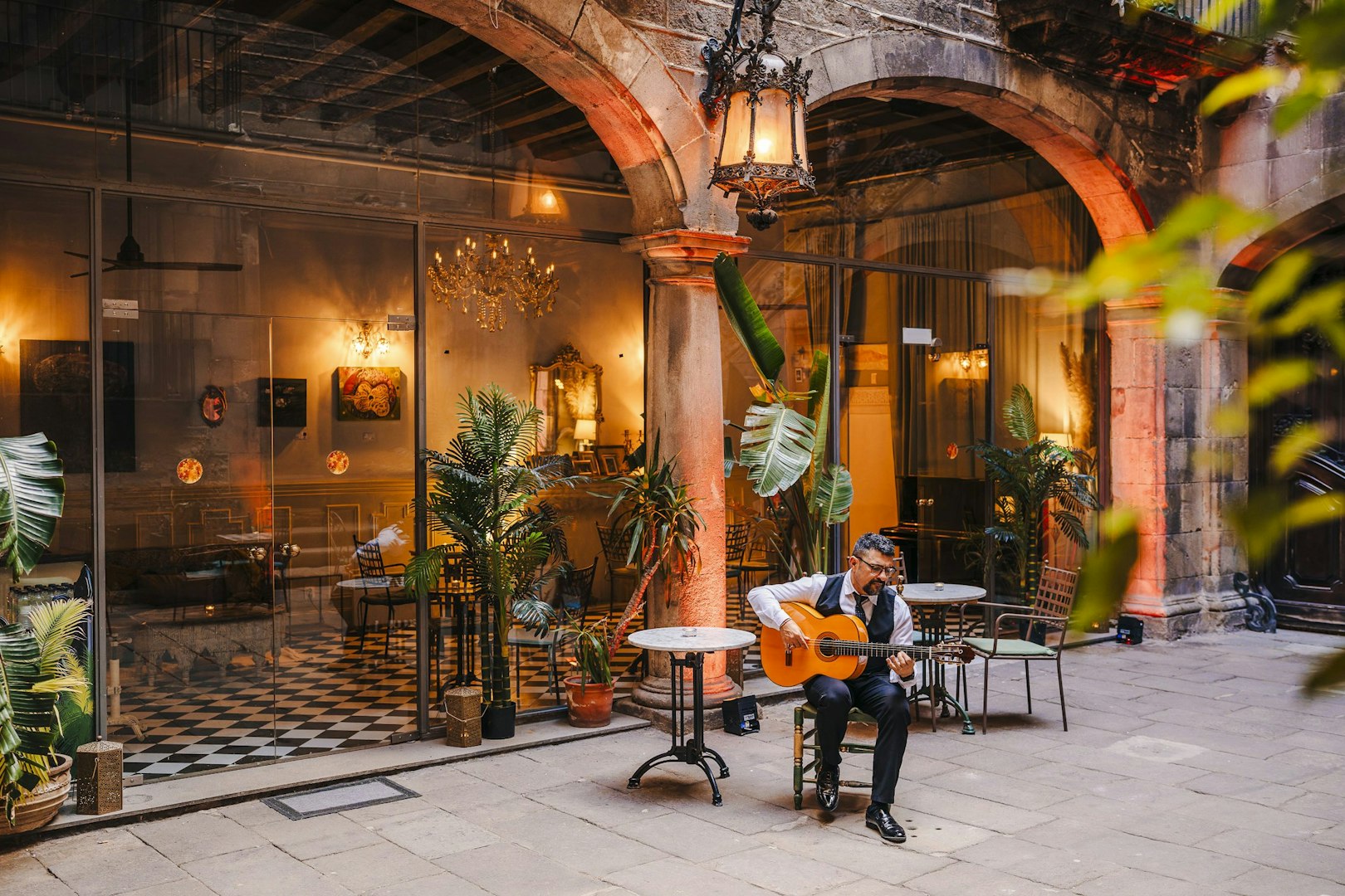 Guitarist performing at Palau Dalmases courtyard in Barcelona.