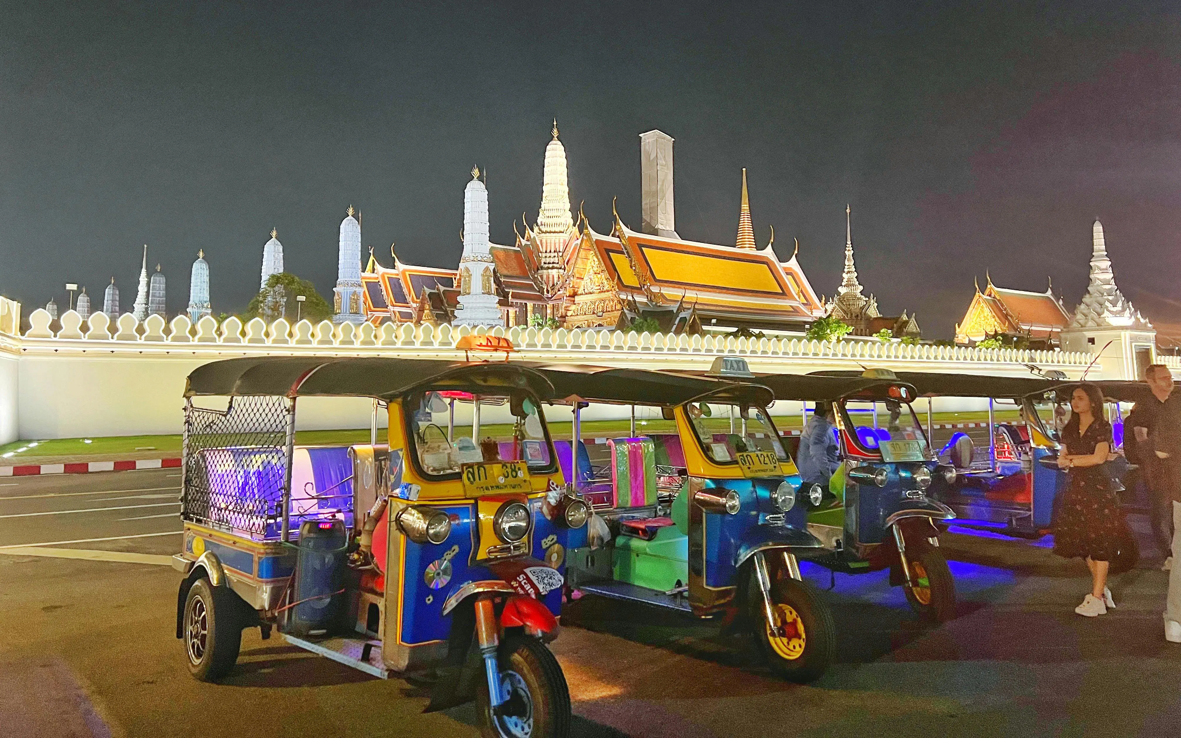 Tuk tuks parked in front of the Grand Palace at night, Bangkok.