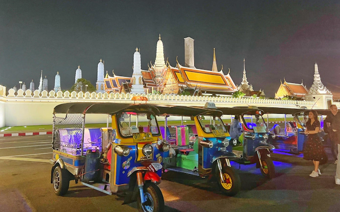 Tuk tuks parked in front of the Grand Palace at night, Bangkok.