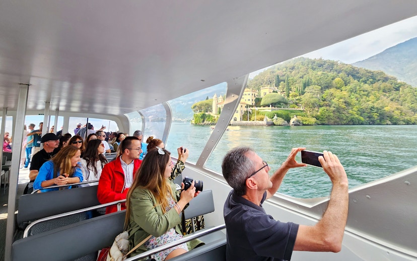 Cruise passengers photographing Bellagio and mountains on Lake Como.