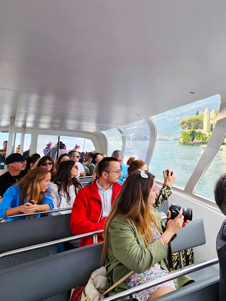Cruise passengers photographing Bellagio and mountains on Lake Como.