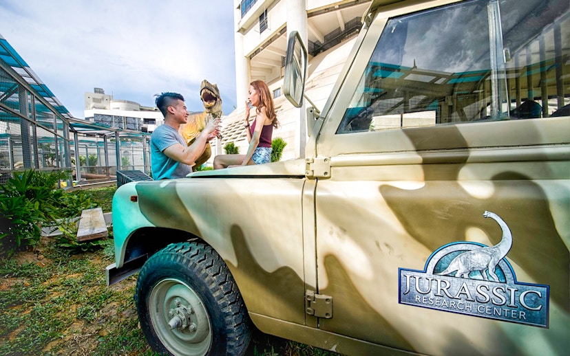 Visitors interacting with a dinosaur model at Jurassic Research Center, Penang.