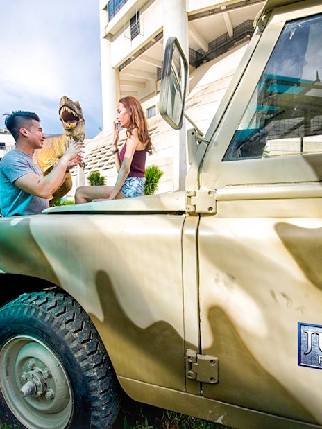 Visitors interacting with a dinosaur model at Jurassic Research Center, Penang.