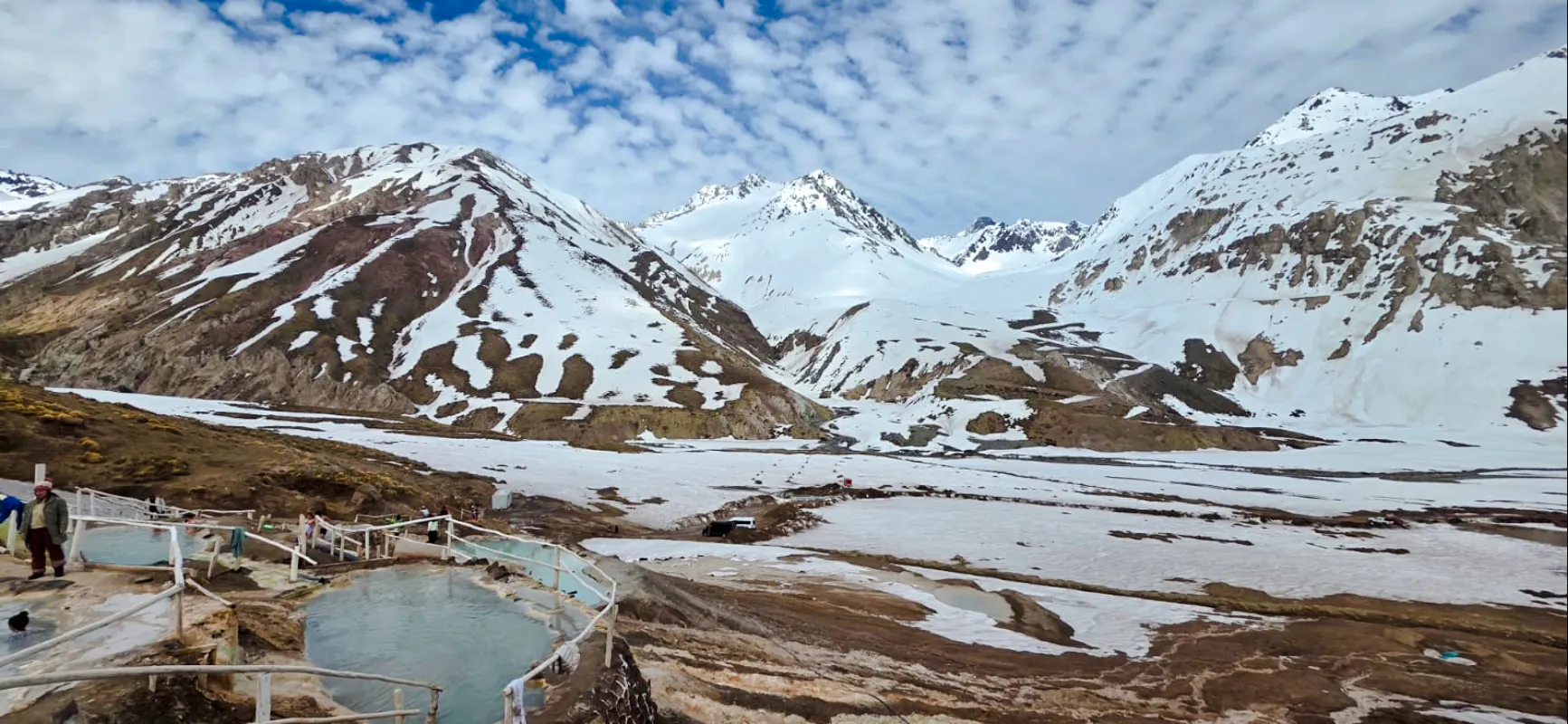 Hot springs at Termas Baños Colina with snow-capped Andes in Cajon del Maipo, Santiago.