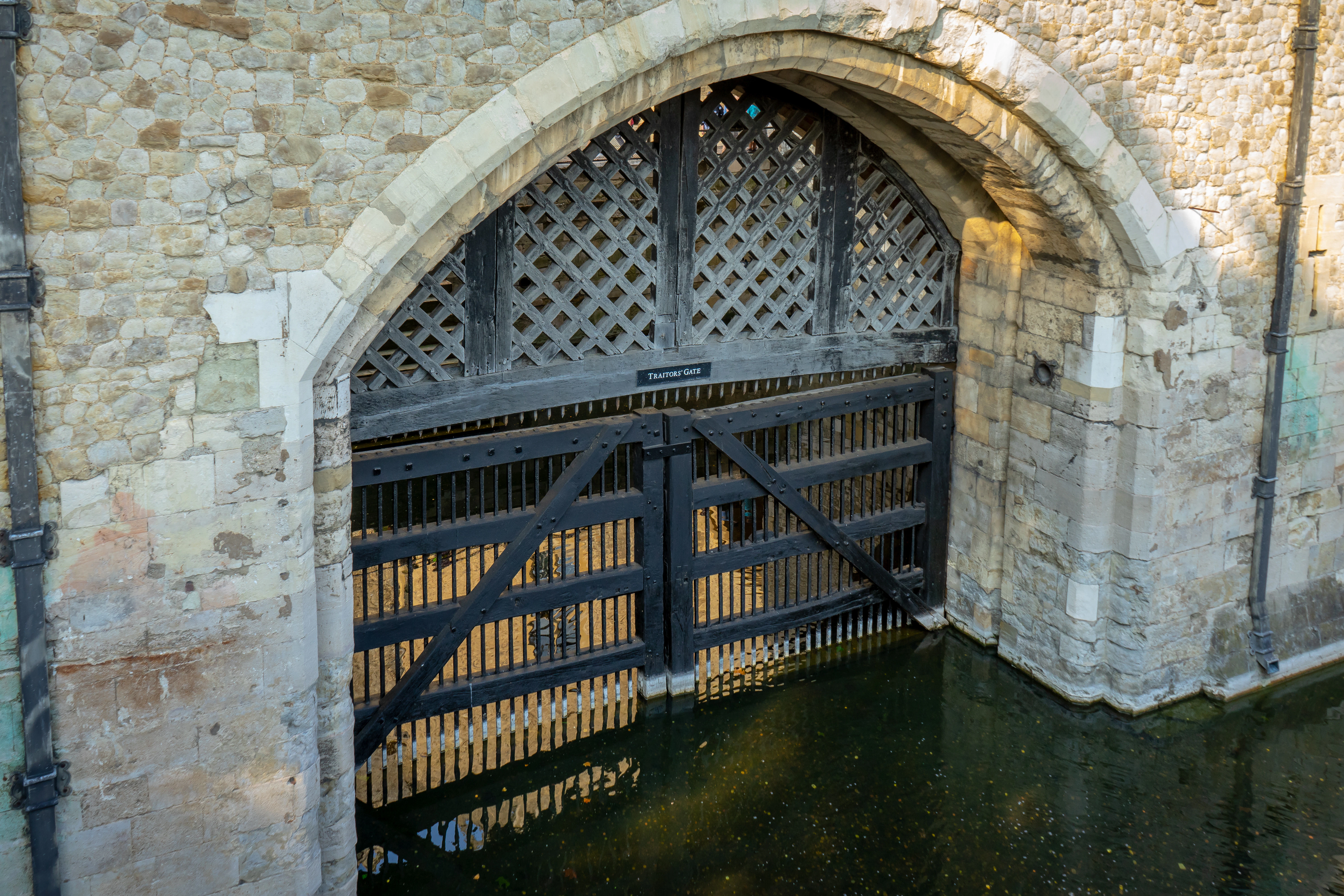 Traitors' Gate at the Tower of London, UK, with water reflecting the historic stone archway.