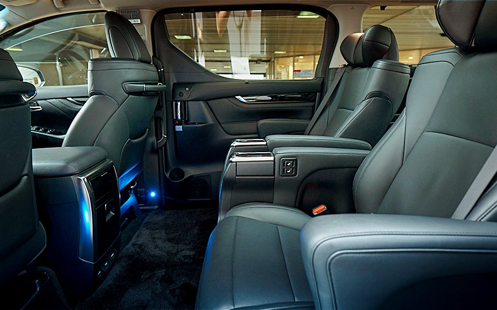 Interior of luxury shuttle transfer to Tokyo Disneyland with spacious seating.