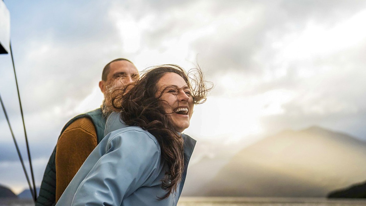 Couple enjoying the view on Doubtful Sound overnight cruise from Manapouri.