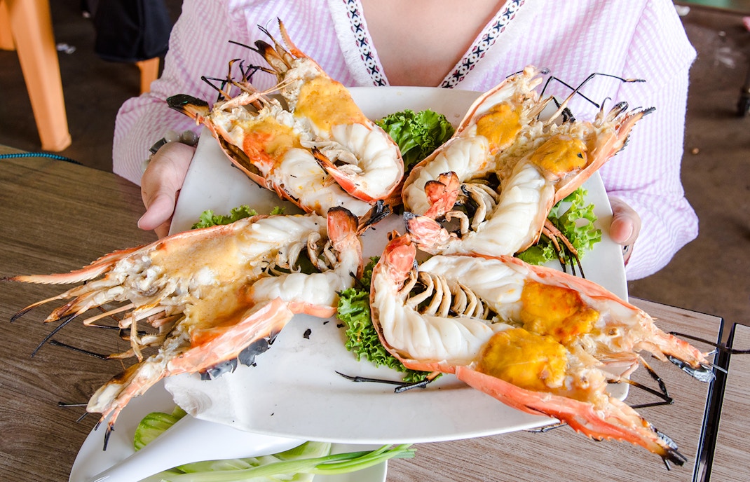 Grilled prawns served on a plate with lettuce at a restaurant.