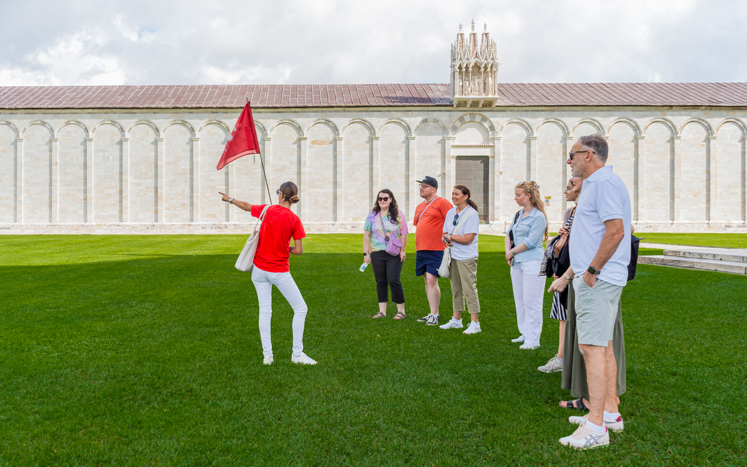 Tour guide with tourists at the Tower of Pisa Complex, Italy.