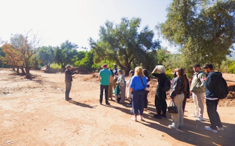 Tourists on guided hike at Ouzoud Waterfalls, Morocco, with a guide explaining the surroundings.