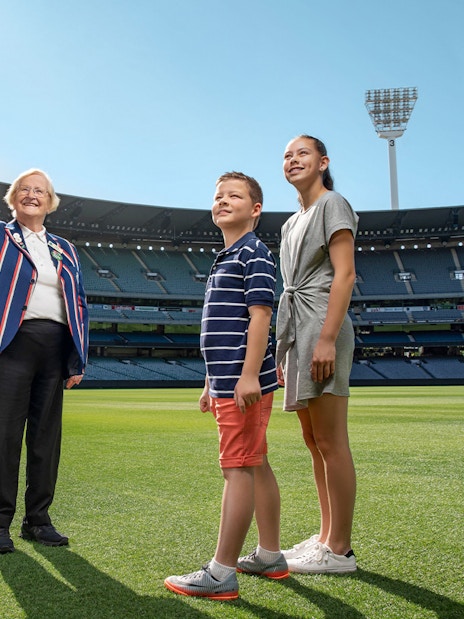 Tour guide with visitors on the field of MCG Stadium during Melbourne sports walking experience.