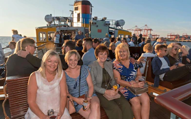 Passengers enjoying a scenic ride on a Mersey Ferry with views of the Liverpool waterfront.
