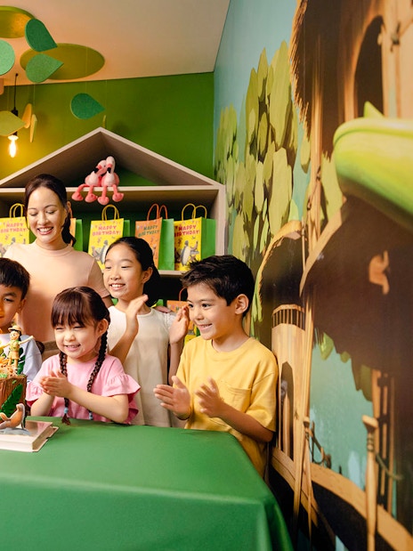 Children celebrating a birthday at Curiosity Cove with a themed cake and decorations.