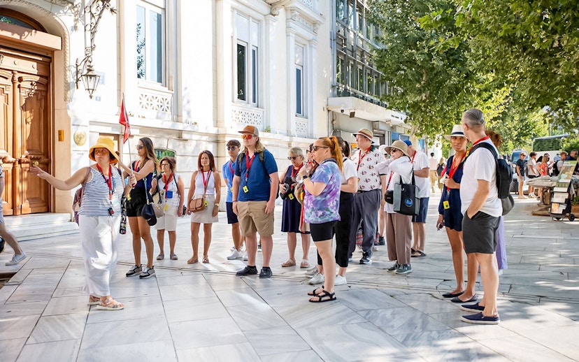 Tour group with audio guides outside Acropolis Parthenon in Athens.