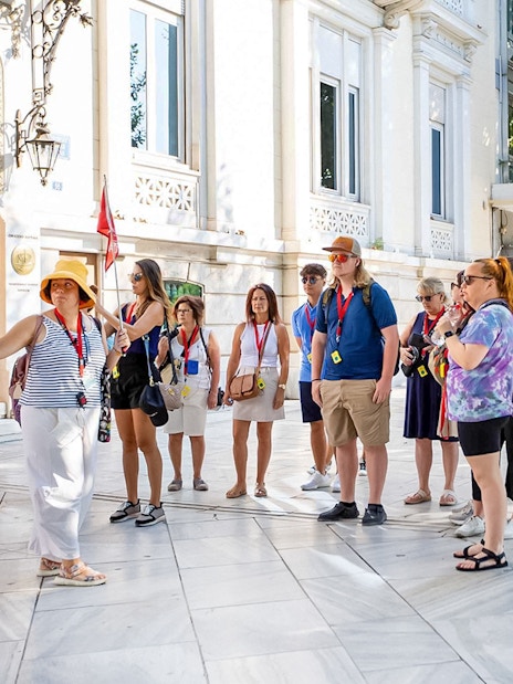 Tour group with audio guides outside Acropolis Parthenon in Athens.