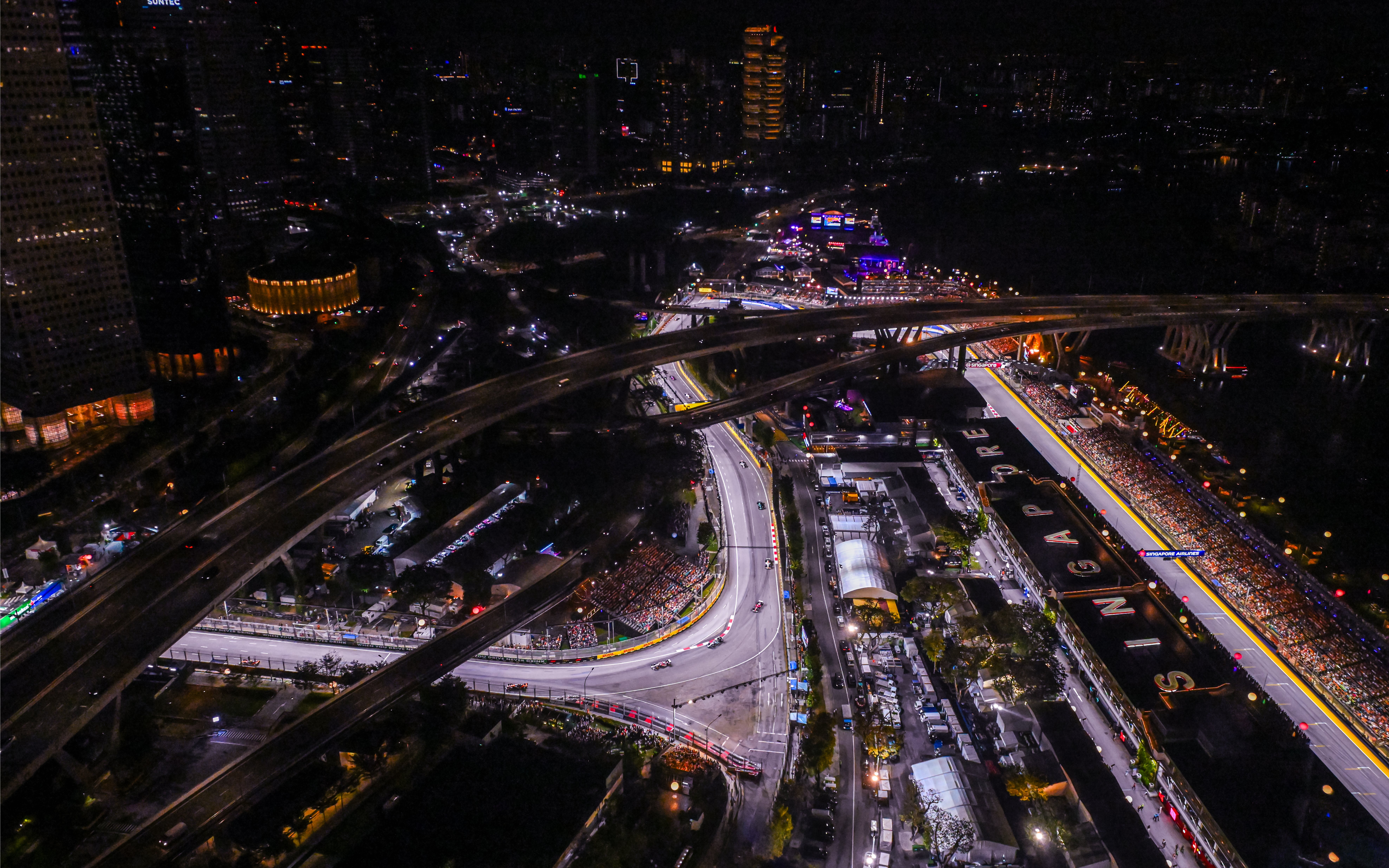 Aerial view of Singapore Grand Prix circuit at night with city lights.