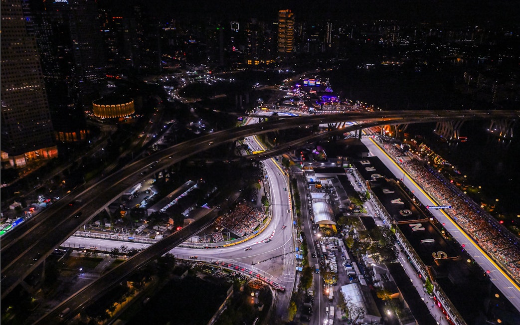 Aerial view of Singapore Grand Prix circuit at night with city lights.