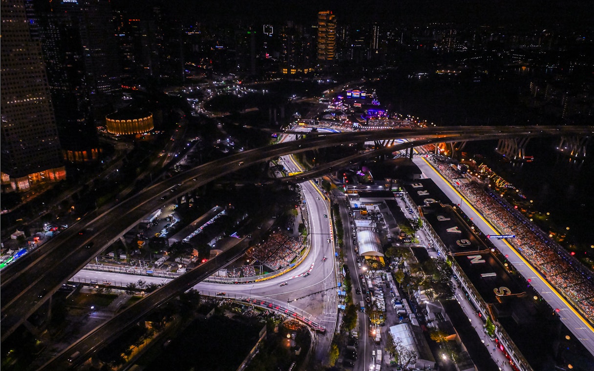 Aerial view of Singapore Grand Prix circuit at night with city lights.