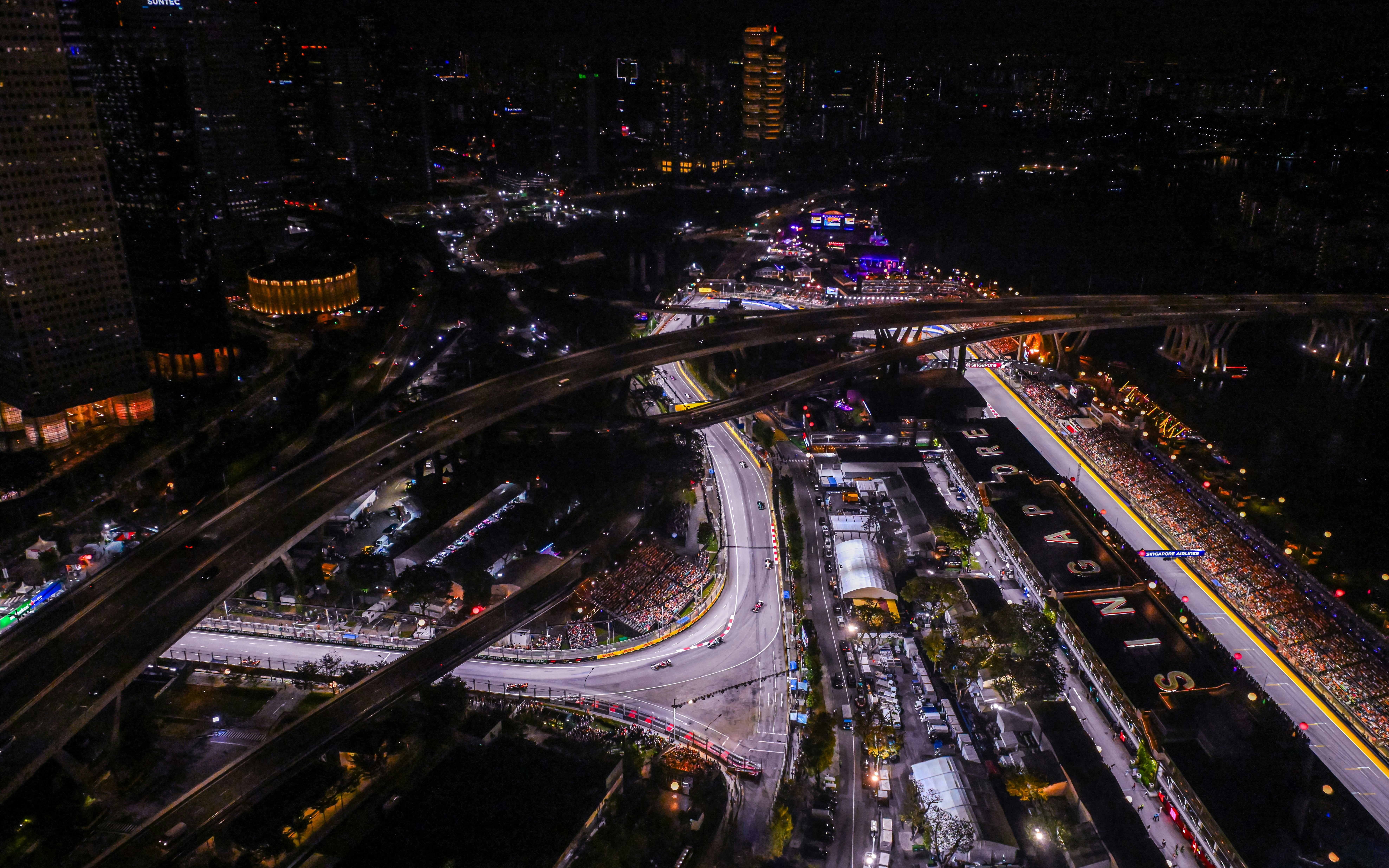 Aerial view of Singapore Grand Prix circuit at night with city lights.