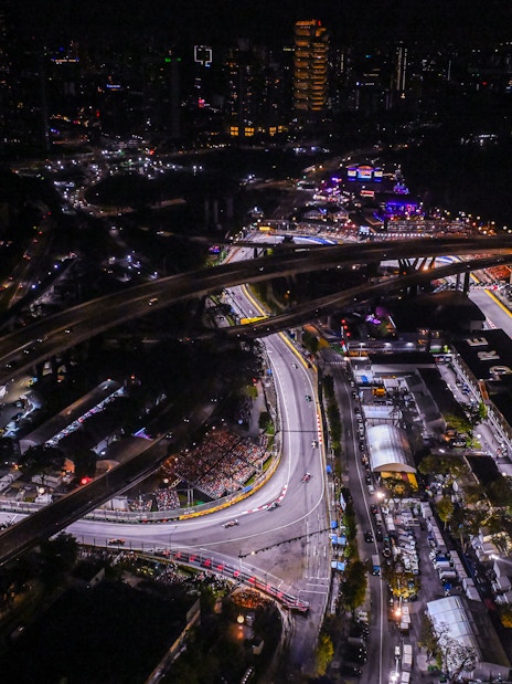 Aerial view of Singapore Grand Prix circuit at night with city lights.
