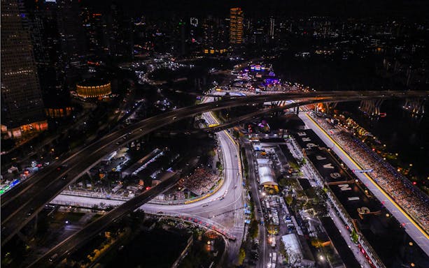 Aerial view of Singapore Grand Prix circuit at night with city lights.