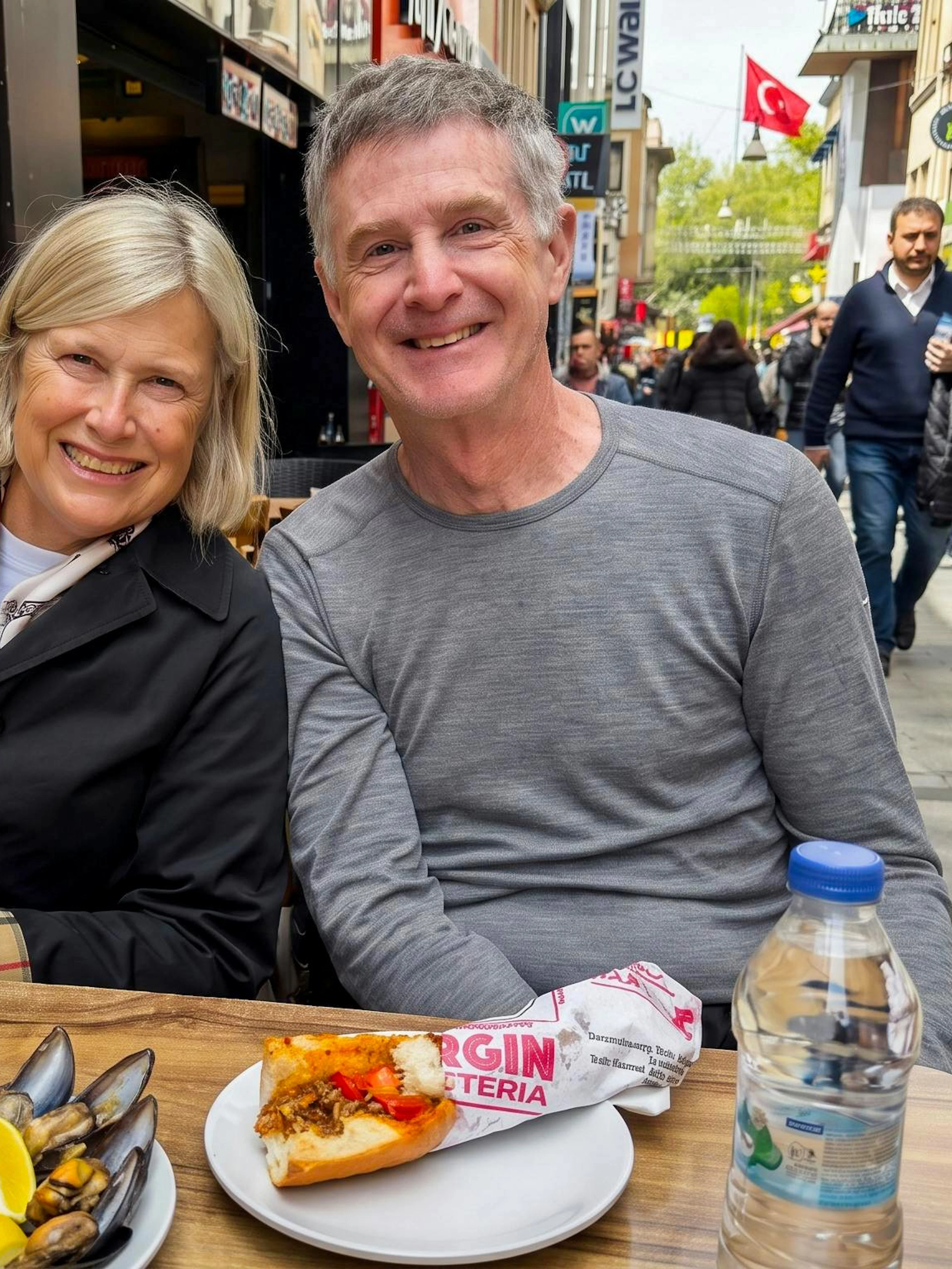 Couple enjoying street food at an outdoor cafe during an Istanbul food tour.