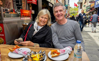 Couple enjoying street food at an outdoor cafe during an Istanbul food tour.