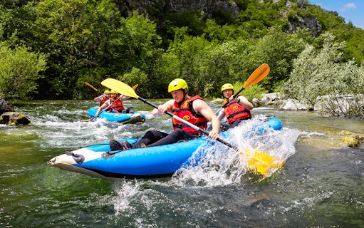 Canoe Safari tour participants paddling through a river near Split.