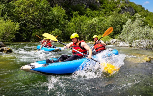 Canoe Safari tour participants paddling through a river near Split.