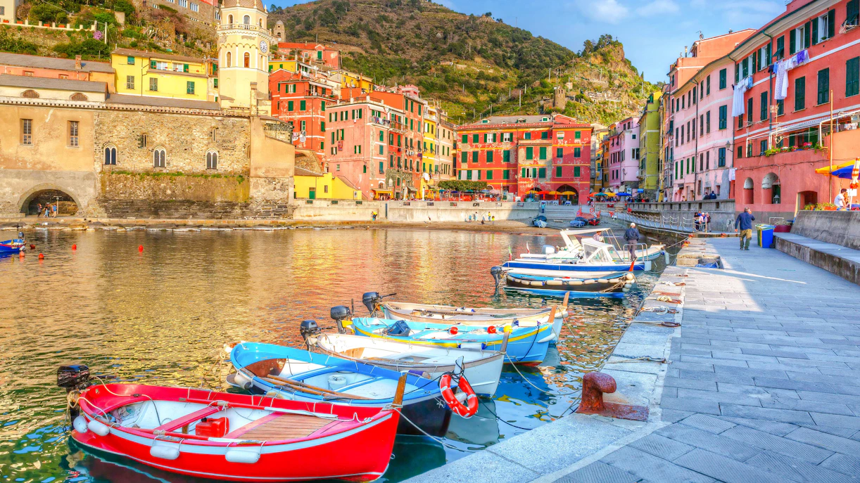 Boats docked along the colorful waterfront of Vernazza, Ligurian Sea, Italy.