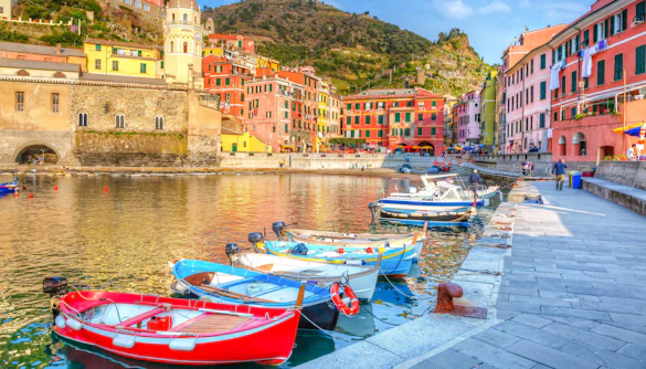 Boats docked along the colorful waterfront of Vernazza, Ligurian Sea, Italy.