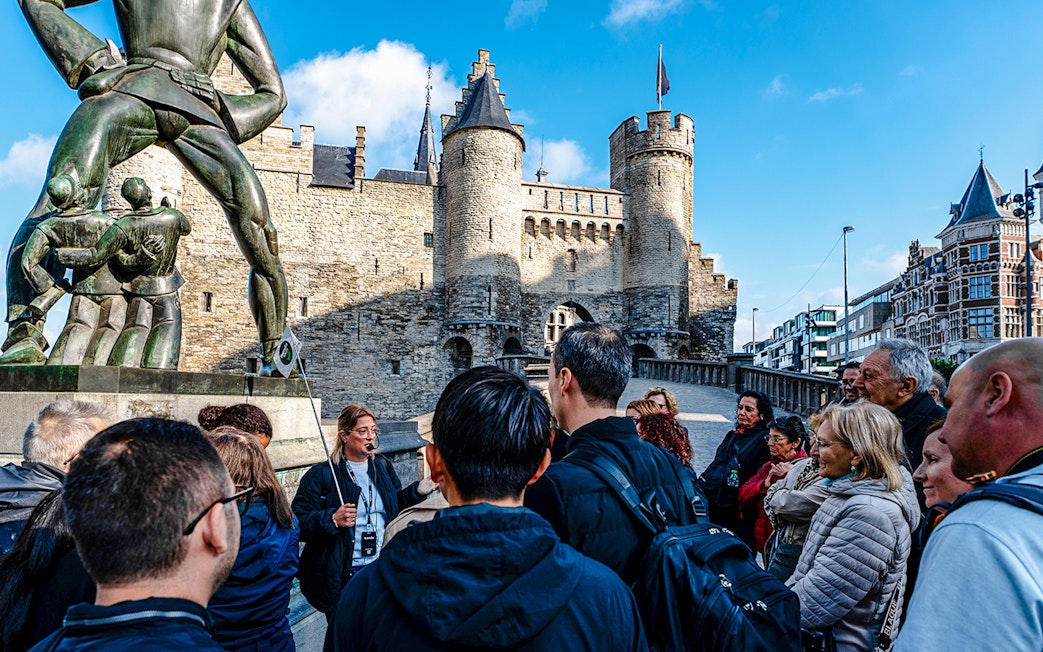 Guests on a guided tour in front of Het Steen Castle in Antwerp, Belgium.