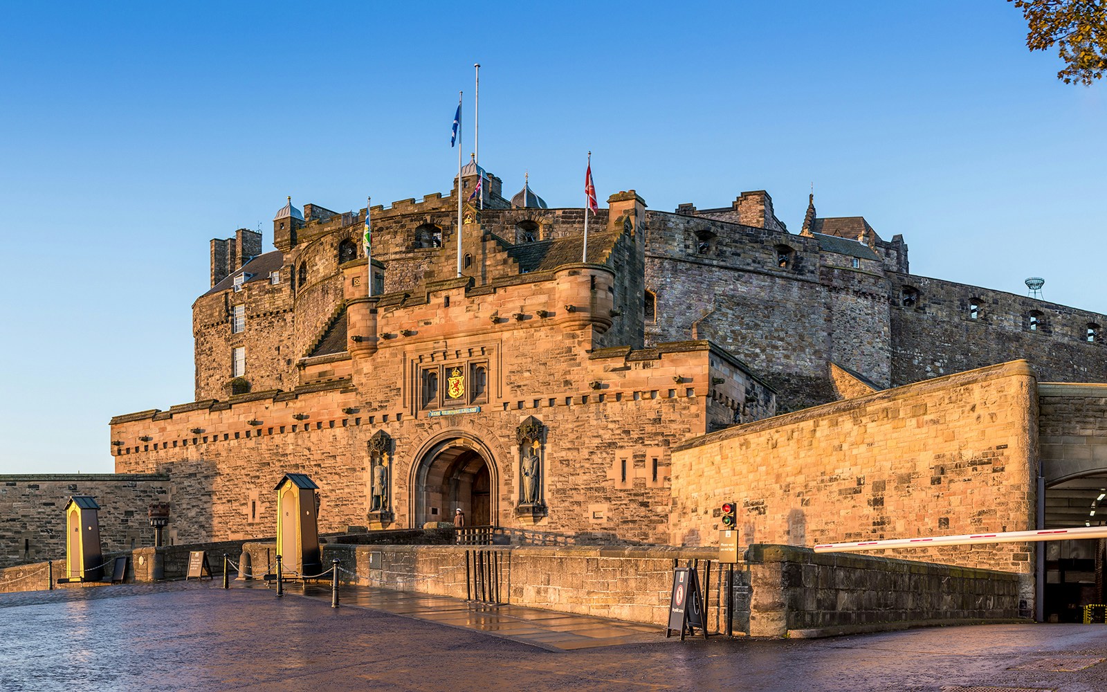 Edinburgh Castle entrance with stone walls and flags in Scotland.