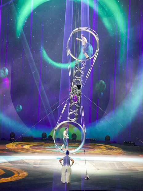 Acrobats performing at La Perle by Dragone in Dubai with vibrant stage lighting.