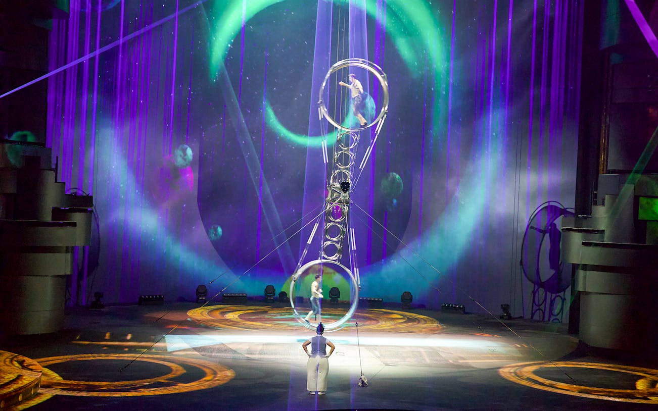 Acrobats performing at La Perle by Dragone in Dubai with vibrant stage lighting.