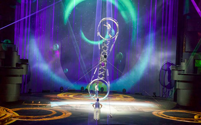 Acrobats performing at La Perle by Dragone in Dubai with vibrant stage lighting.