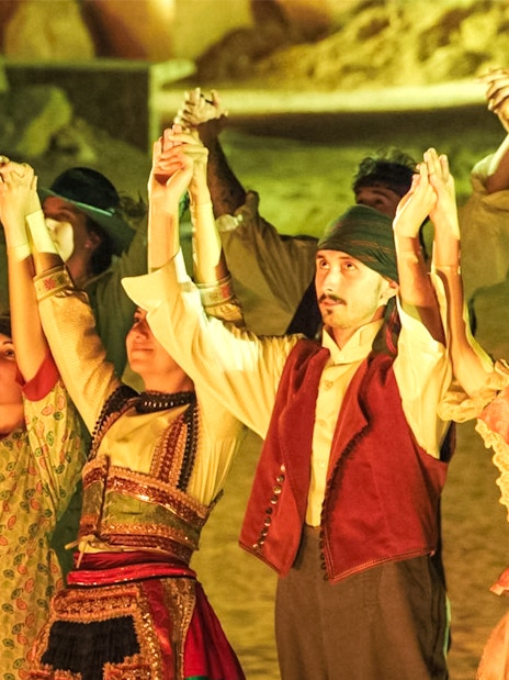 Performers in traditional costumes holding hands during The Dream of Toledo Night Show.