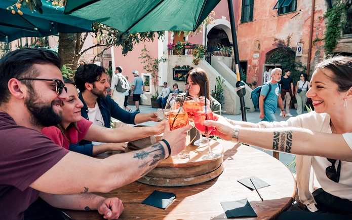 Group enjoying drinks at an outdoor café in Cinque Terre, Italy.