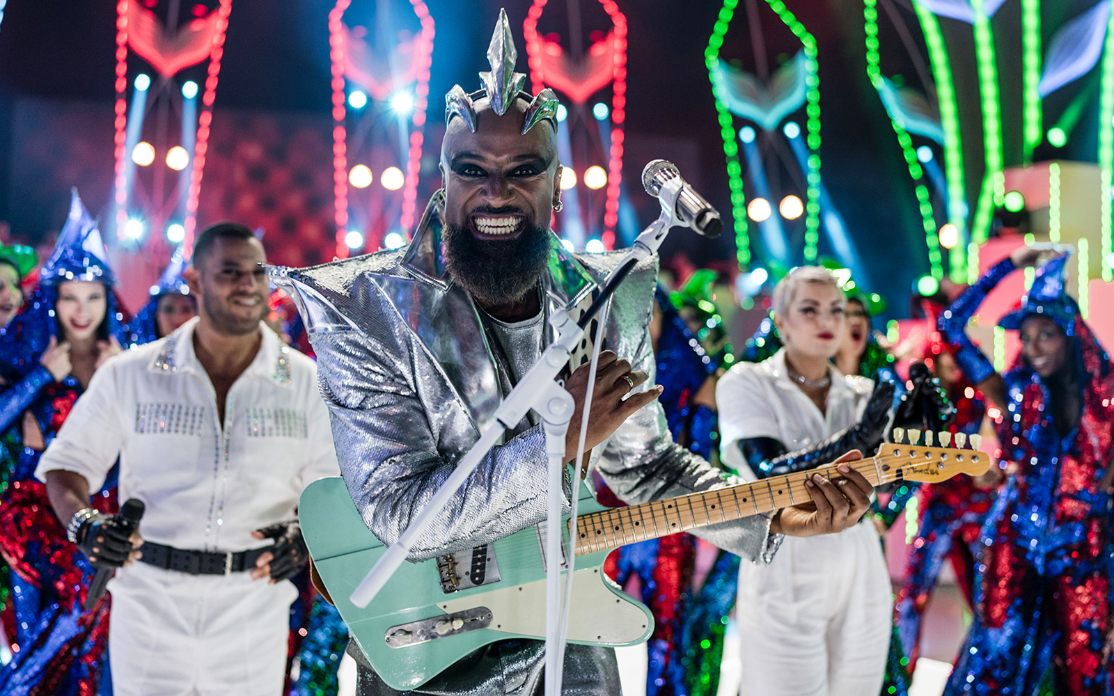 Performer in silver costume playing guitar at FALLING | IN LOVE Grand Show.