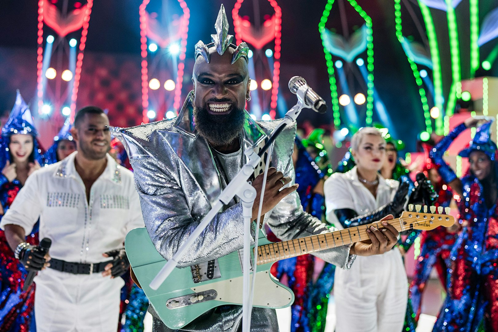 Performer in silver costume playing guitar at FALLING | IN LOVE Grand Show.