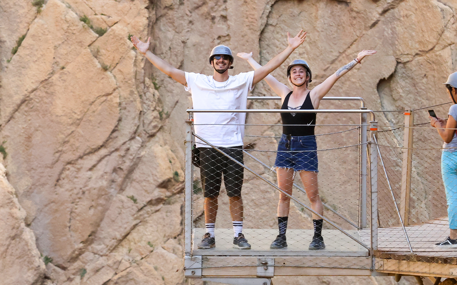 Tourists on a platform at Caminito del Rey with mountain backdrop, Malaga.