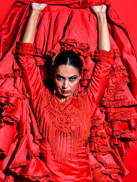 Flamenco dancer in red dress performing at Esencia espectáculo flamenco.