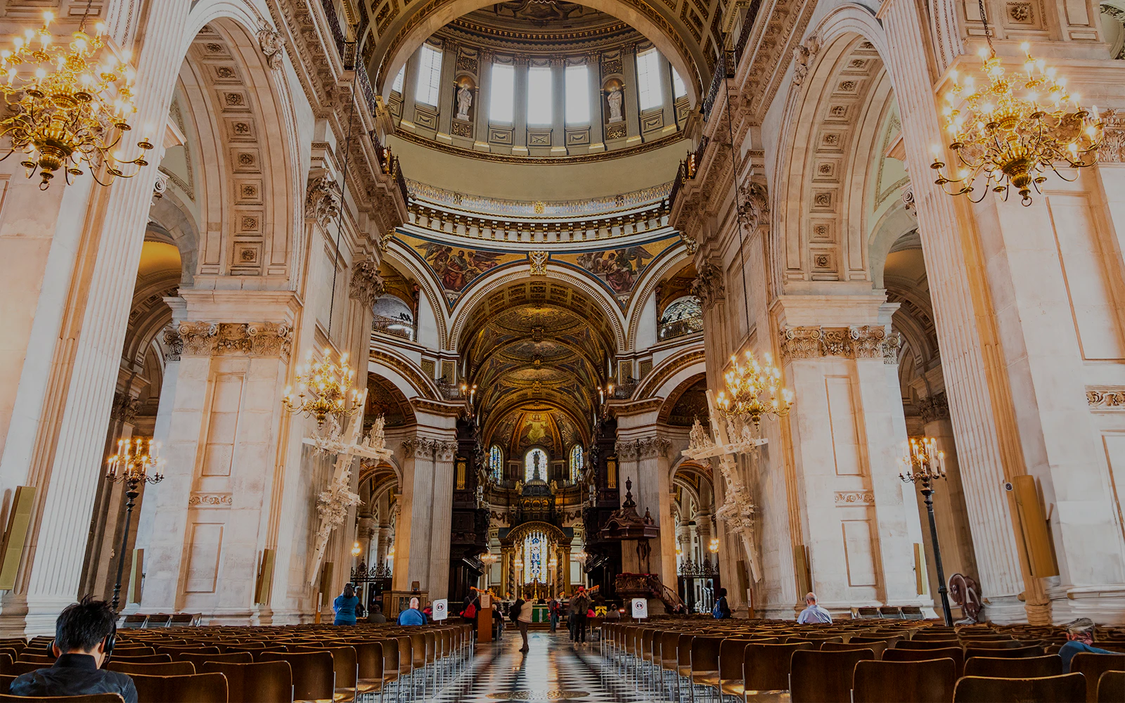St Paul's Cathedral London interior view towards the High Altar with ornate arches and chandeliers.