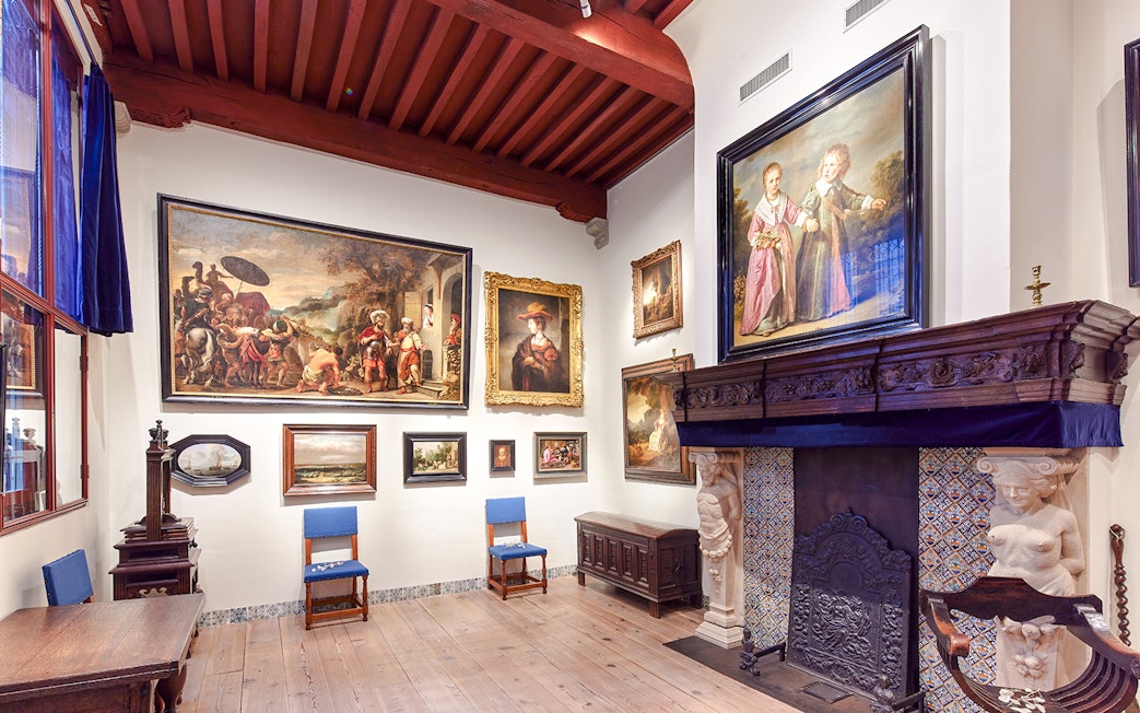 Rembrandt House Museum interior with paintings and ornate fireplace.