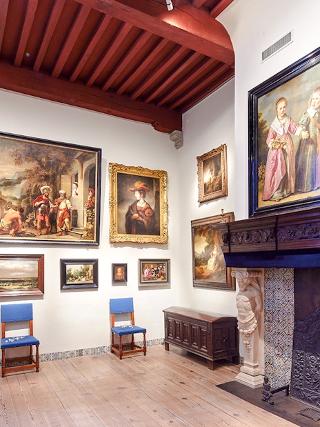 Rembrandt House Museum interior with paintings and ornate fireplace.