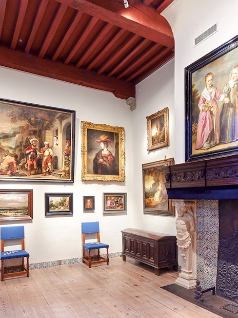 Rembrandt House Museum interior with paintings and ornate fireplace.