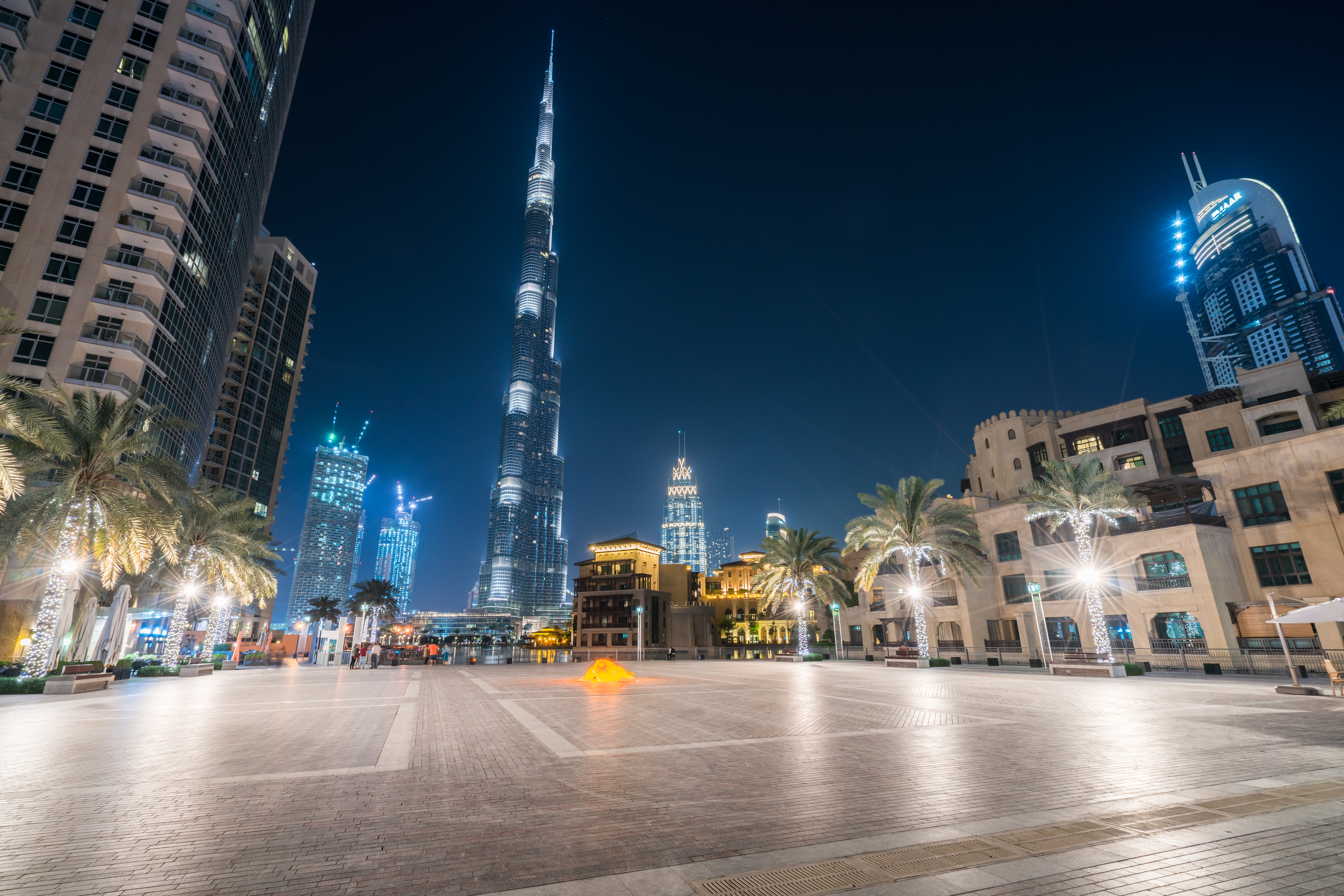 Burj Plaza in Dubai at night with Burj Khalifa and surrounding skyscrapers.