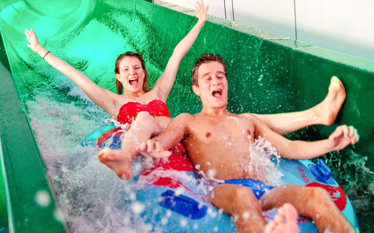 People enjoying a water slide at Aquaboulevard de Paris.