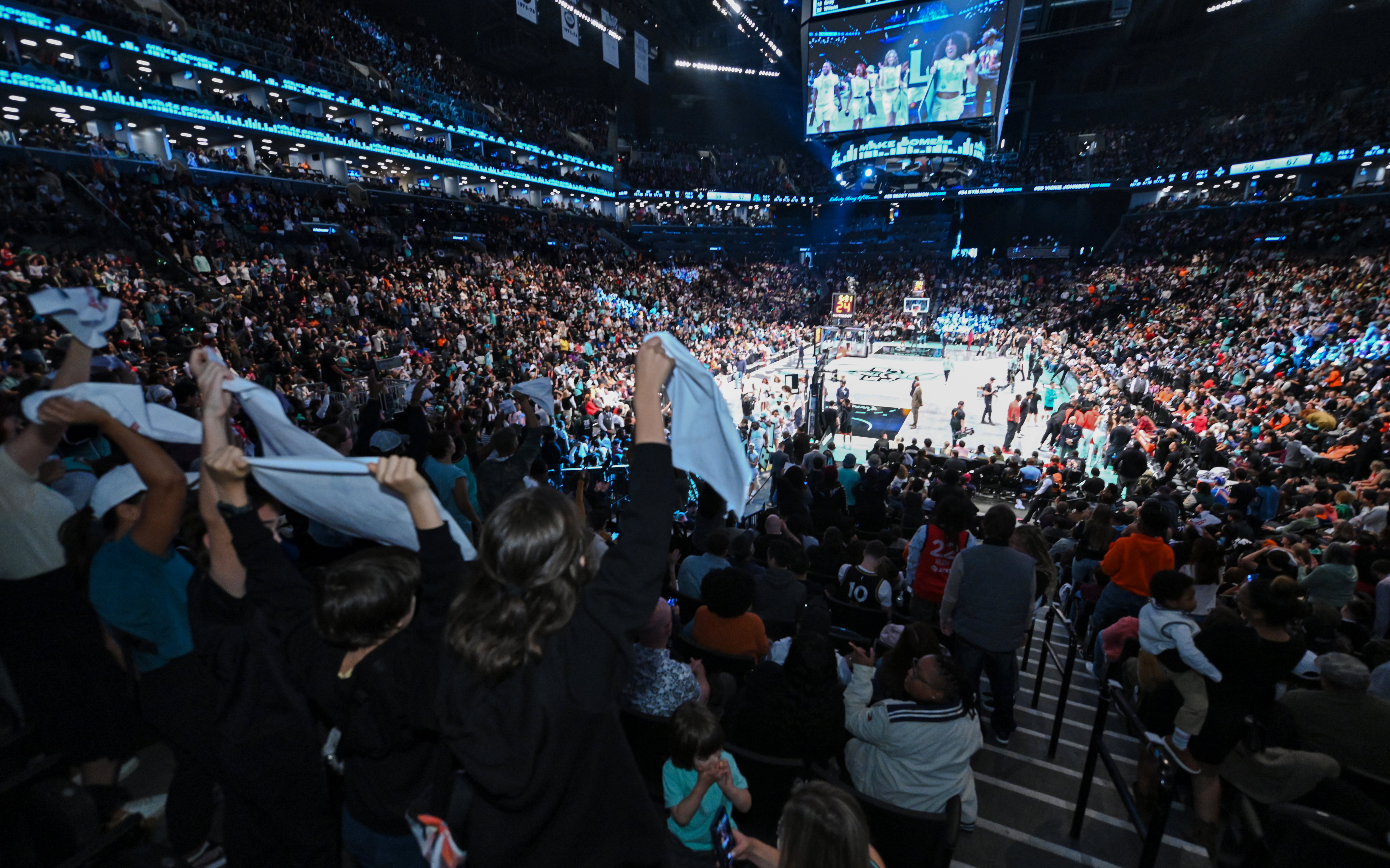 Crowd cheering at a New York Liberty WNBA game in New York arena.